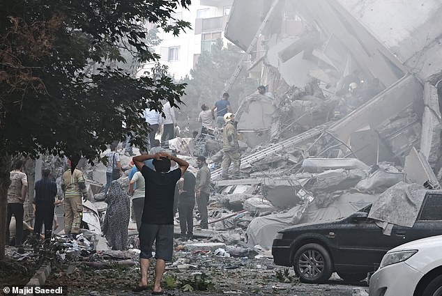 People look over damage to buildings in Nobonyad Square following Israeli airstrikes