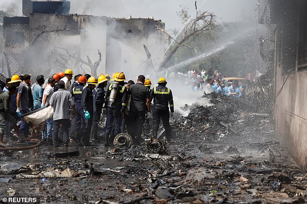 Firefighters work to put out a fire at the site where an Air India Boeing 787 Dreamliner plane crashed in Ahmedabad