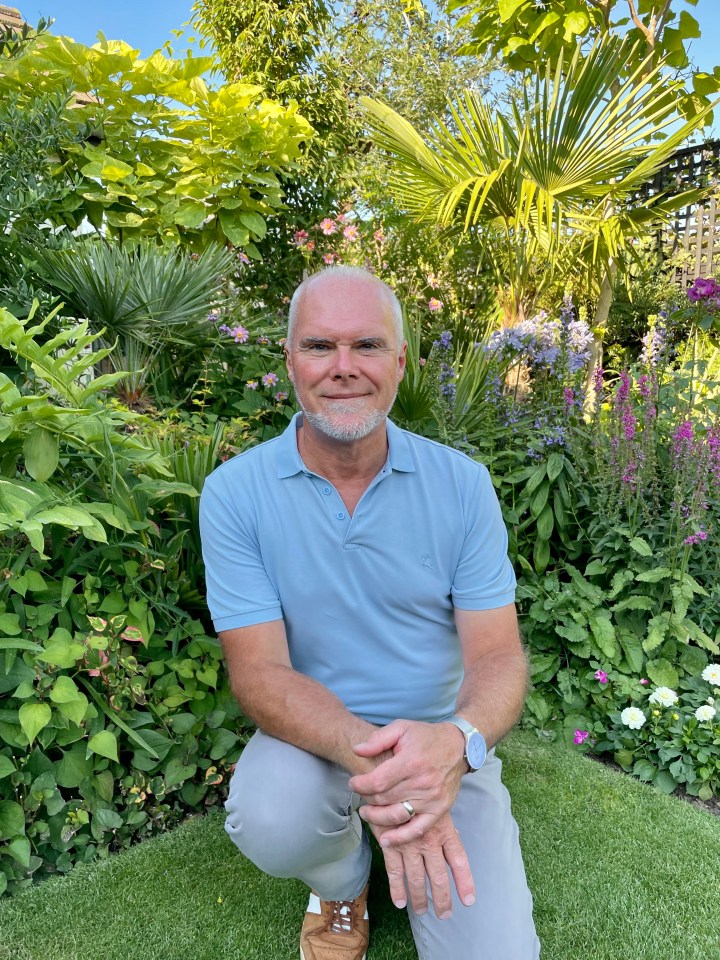 Man kneeling in a garden.