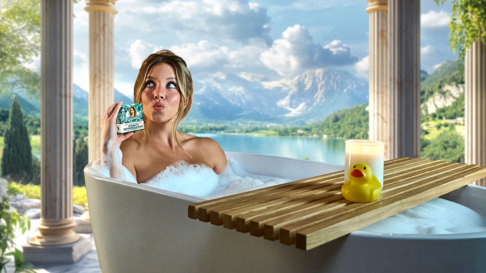 Sydney Sweeney in a bubble bath holding a bar of soap.