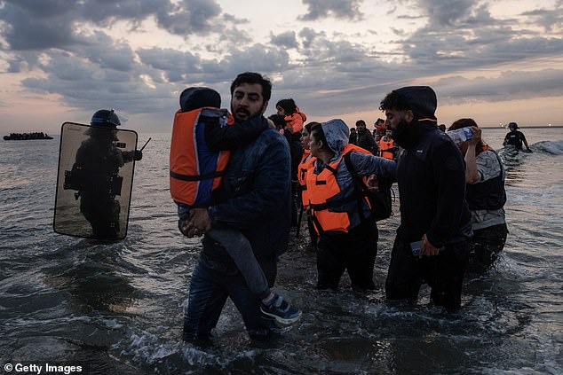 French Police enter the water to try and stop migrants boarding small boats on Friday