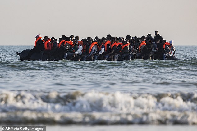 An overloaded dinghy is pictured as it attempts to make the perilous journey cross the Channel from France