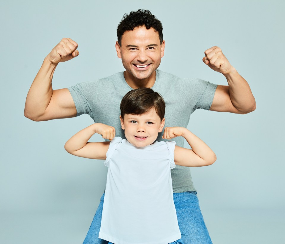 Ryan Thomas flexing his biceps with his children.