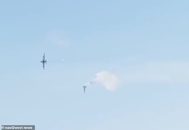 The right wing is seen falling from the stricken aircraft - and the pilot's parachute is visible after ejecting