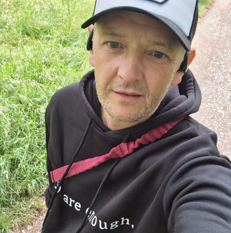 Man in black hoodie outdoors.