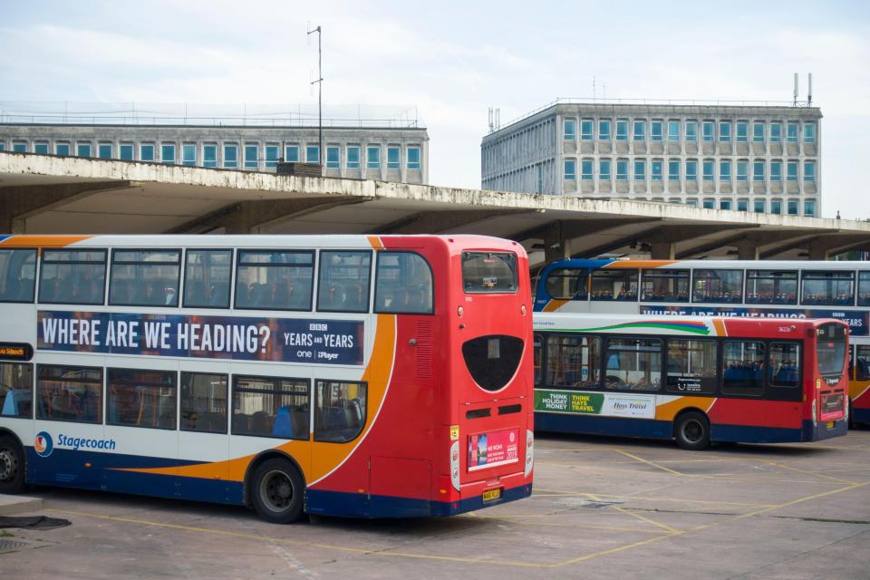 Modernist bus station in Exeter, UK, with buses parked under a canopy.