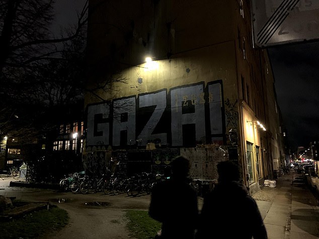 Bicycles stacked by a graffitied wall in Copenhagen, November 2019