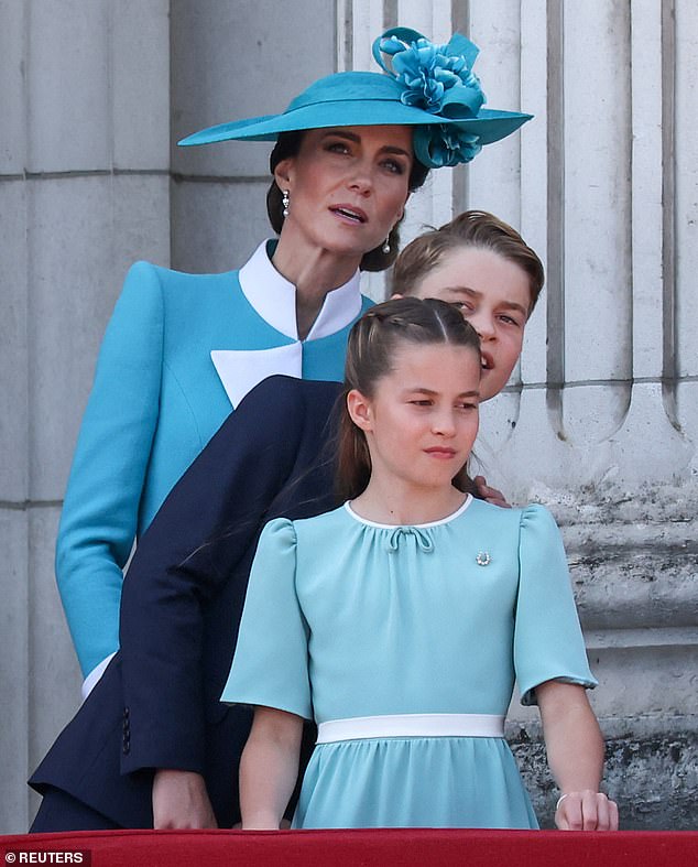 Princess Kate peers to get a good view of the RAF flypast, as George and Charlotte watch on