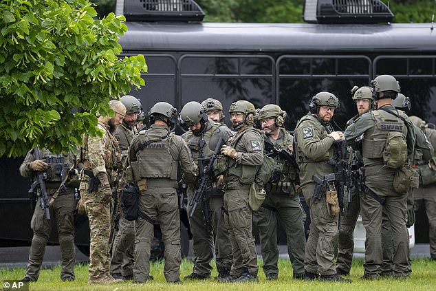 Law enforcement officers including local police, sheriffs and the FBI, stage less than a mile from a shooting in Brooklyn Park, Minnesota