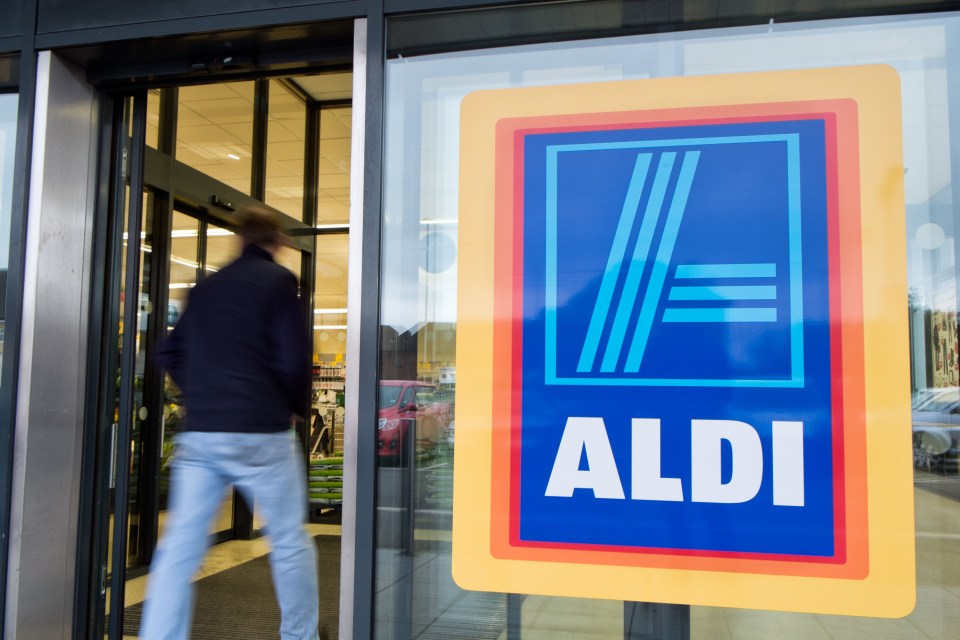 A motion-blurred man entering an Aldi supermarket.