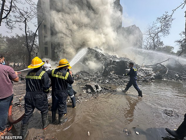 Rescue team members work as smoke rises at the site in Ahmedabad, India, June 12, 2025