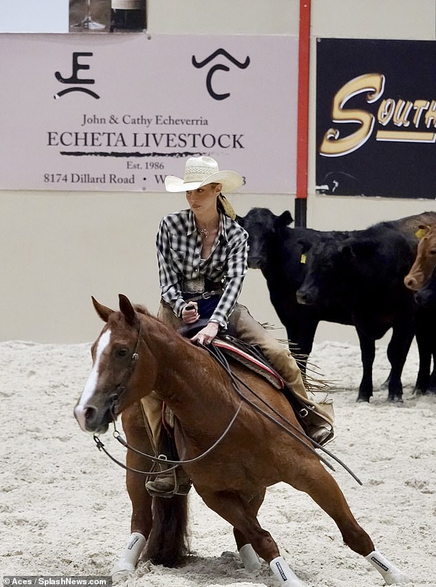 Bella looked at home on her horse in a black and white checked shirt, beige chaps over jeans and a white cowboy hat