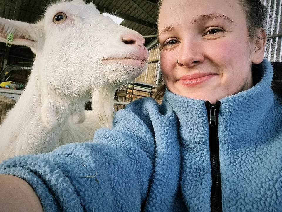 Woman and goat nuzzling.