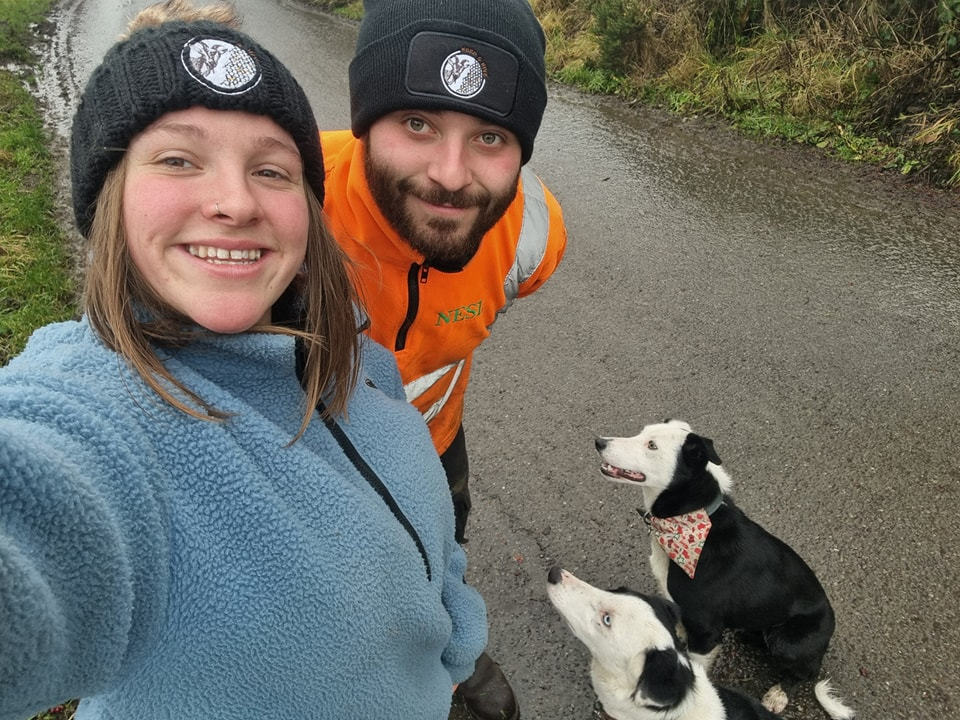 Couple and two dogs on a walk.