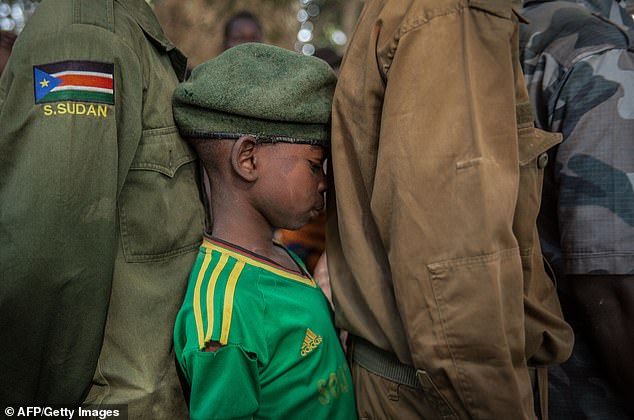 The University of Exeter was also £784,000 to build a historical account of the development of child soldiering in Africa. Pictured: Child soldiers wait in a line for their registration during the release ceremony in Yambio, South Sudan