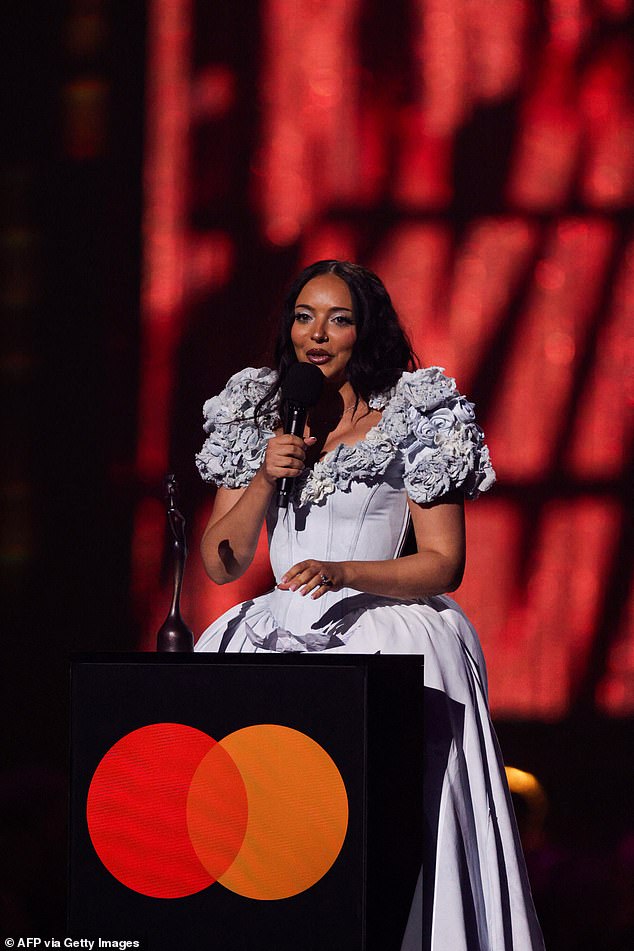 As her name was read out, the singer gasped in shock before excitedly making her way to the stage, where she amusingly struggled to climb the stairs onto the platform