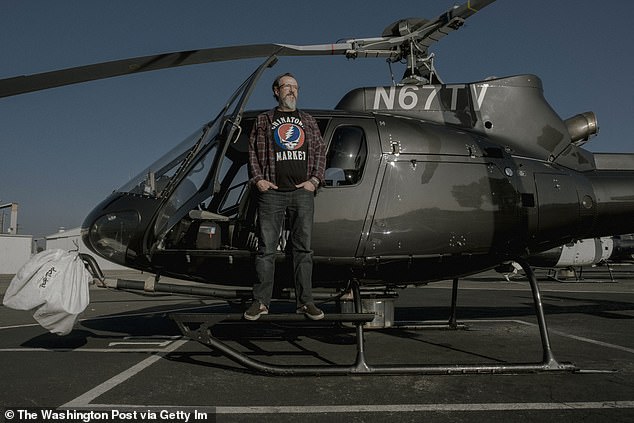 Pictured: Stu Mundel poses with one of the helicopters takes in the air for his reporting assignments