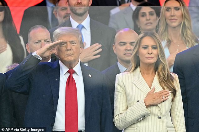 President Donald Trump (left) and first lady Melania Trump (right) listen to the national anthem being played Saturday evening at the start of the 250th anniversary parade for the Army. First son Eric (center top) and his wife Lara Trump (right) can be seen behind the first couple