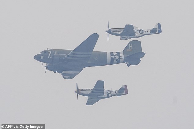A US Army C-47 Skytrain and P-51 fly over the National Mall Saturday during the Army 250th Anniversary Parade in Washington. The predicted thunderstorms held off allowing the flyovers to take place