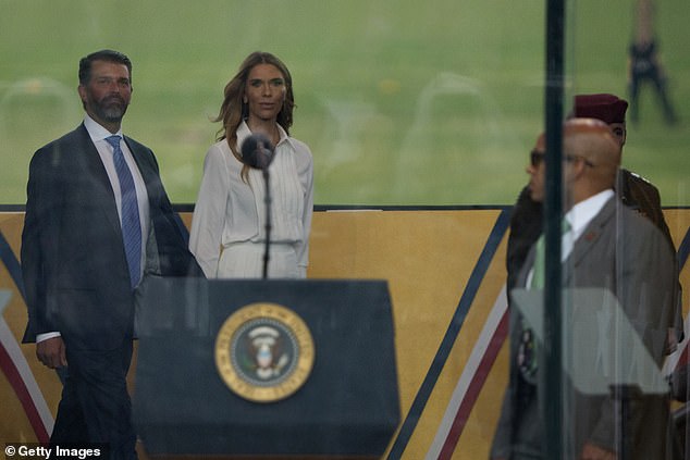 Donald Trump Jr. (left) walks into the viewing box with his girlfriend Bettina Anderson (right) ahead of Saturday's military parade