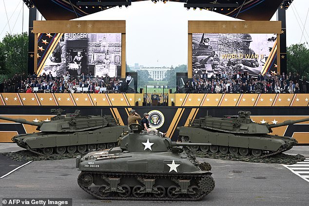 President Donald Trump and first lady Melania Trump watch as a World War II era M4 Sherman tank drives past the viewing stand during Saturday's parade