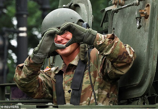 A soldier makes a 'heart hands' gesture from inside a tank during Saturday's 250th anniversary parade for the U.S. Army