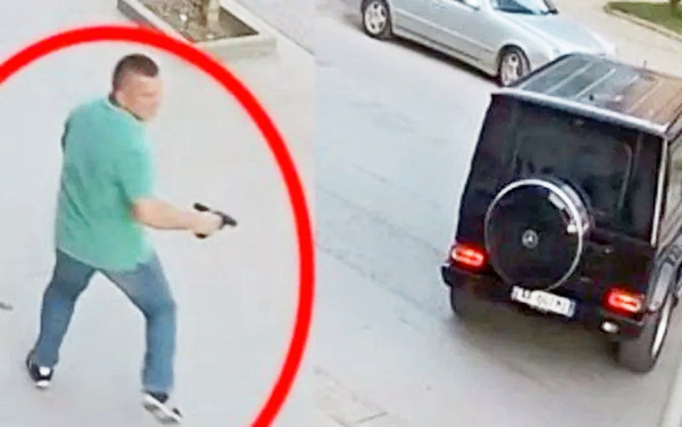Surveillance footage of a man aiming a gun at a black SUV.