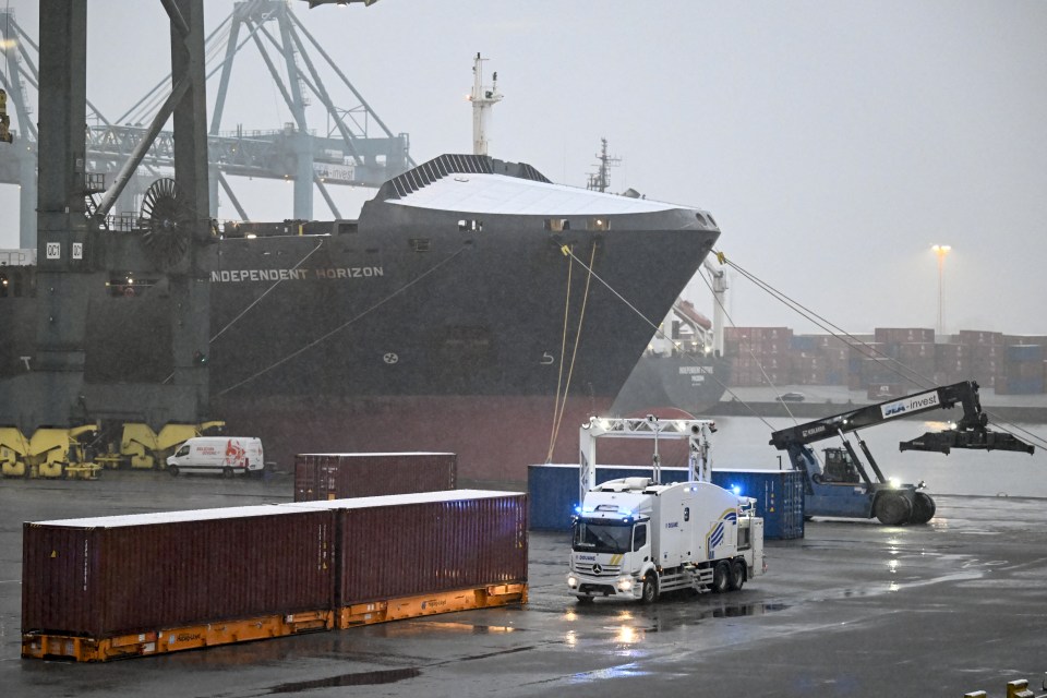 Customs vehicle inspecting cargo containers at the Antwerp harbor.
