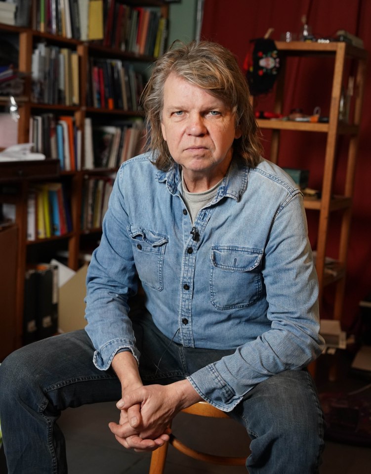 Portrait of a man sitting in a denim shirt.