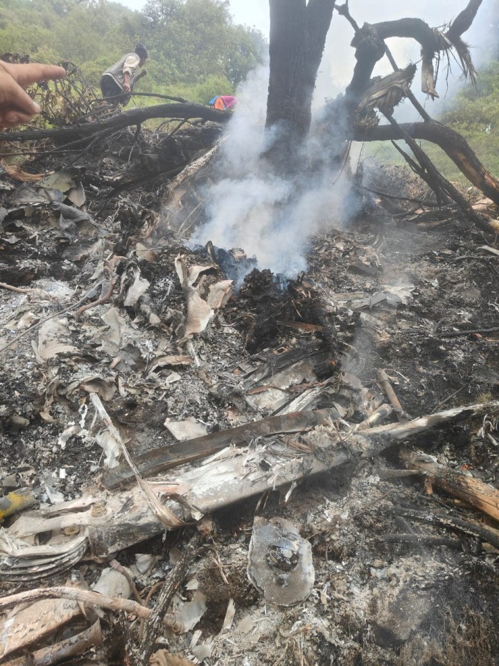 Debris and smoke at the site of a helicopter crash.