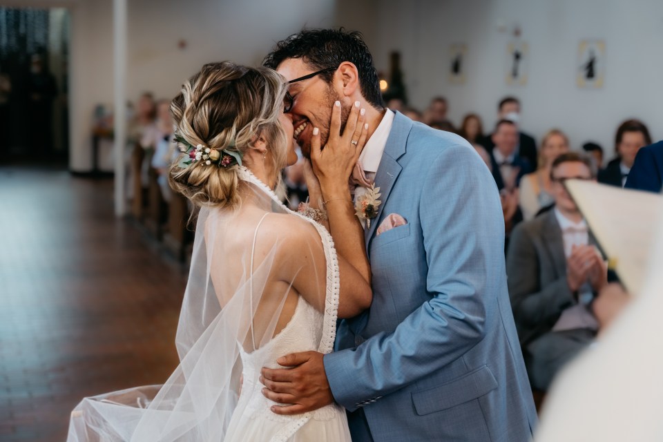 Bride and groom kissing at their wedding ceremony.