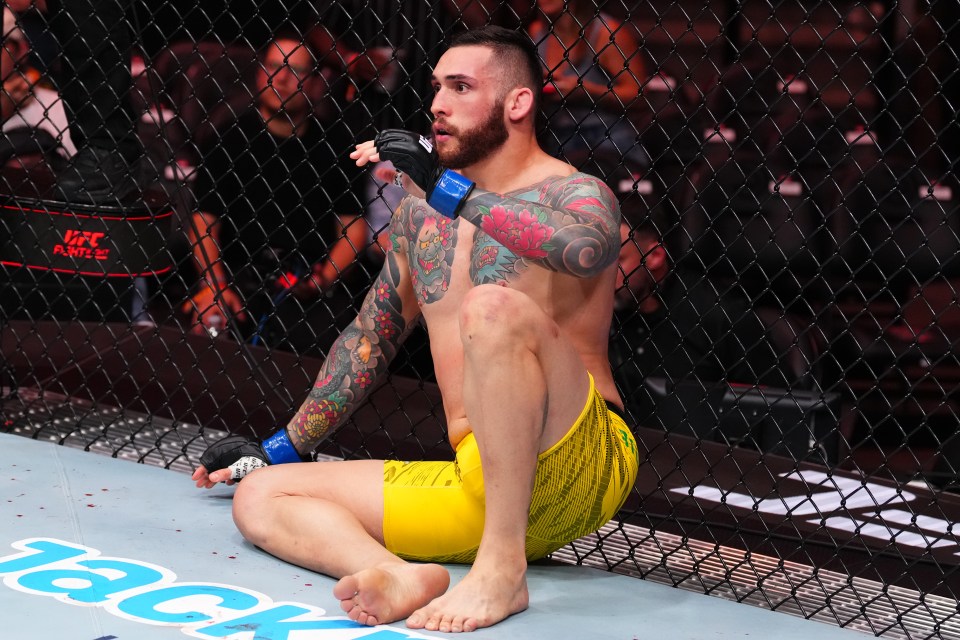 Rodolfo Bellato of Brazil sits against the cage during a UFC fight.