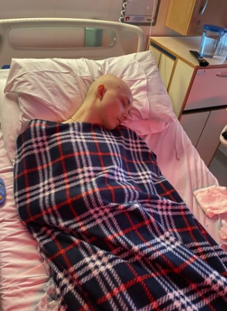 Terminally ill boy sleeping in a hospital bed.