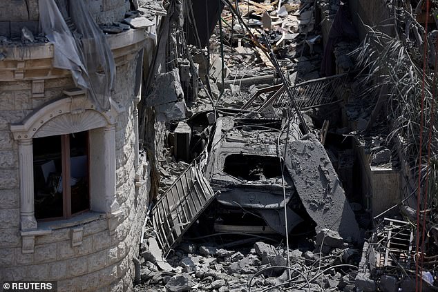 A destroyed vehicle lies under debris after missiles fired from Iran impacted a residential building, in Tamra, northern Israel June 15, 2025