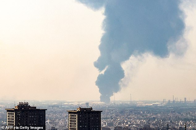 A plume of heavy smoke rises over an oil refinery in southern of Tehran, after it was hit in an overnight Israeli strike, on June 15, 2025