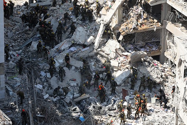 Members of Israel's Home Front Command search for missing people under the rubble of a partially collapsed residential building after Iranian ballistic missiles hit Bat Yam, central Israel, 15 June 2025