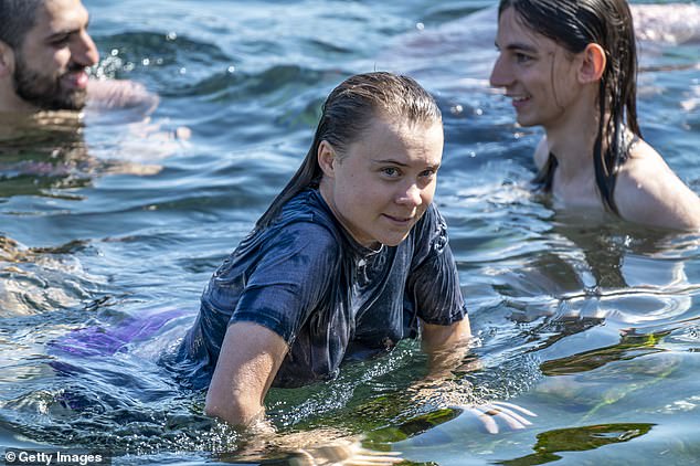 Greta Thunberg enjoys a moment of refreshment and fun in the waters of San Giovanni Li Cuti harbor, in Catania, with Chris