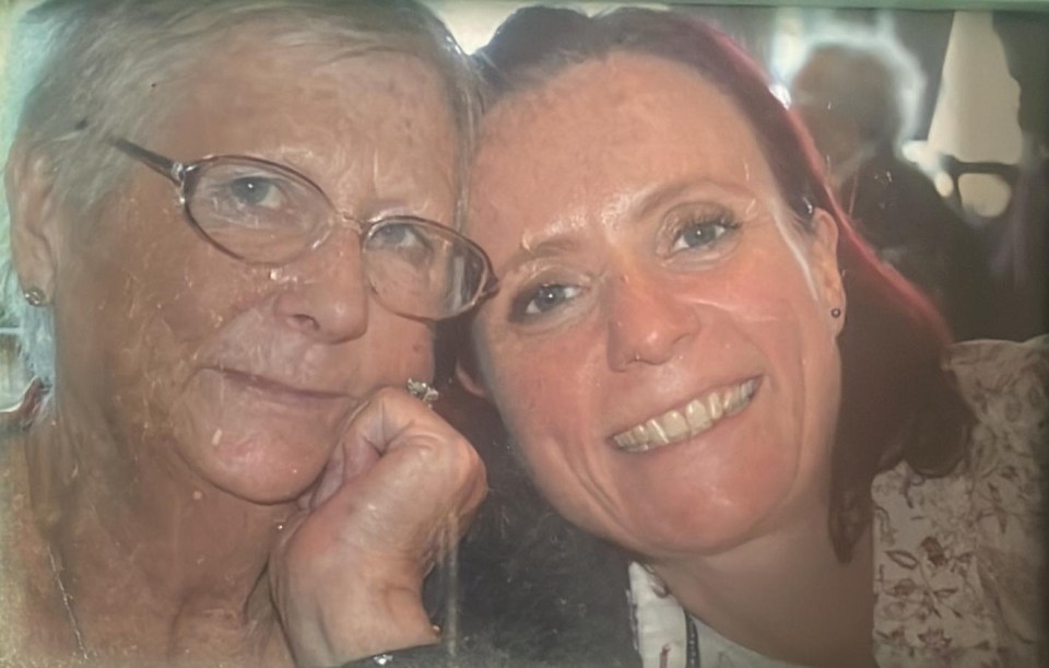 Photo of two women, one older and one younger, posing closely together.