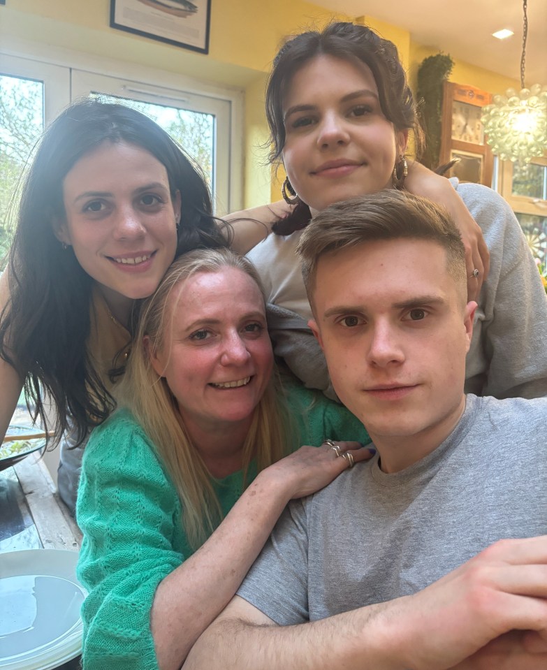 Photo of a family of four posing closely together.