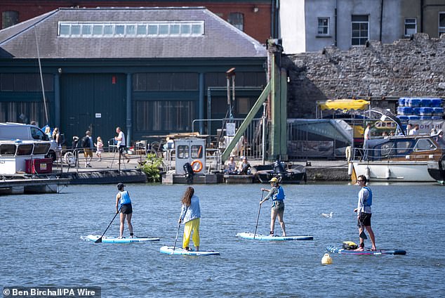 The majority of the country will be blessed with long sunny spells providing more opportunities for weekend sunbathing (pictured: paddle boarders in Bristol)