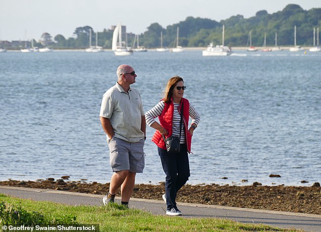 A couple take in the sun at Poole Quay, Dorset on Saturday. The good weather will continue for the rest of the weekend and into next week