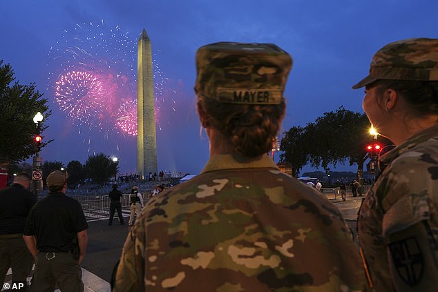 U.S. Army 2nd Lt. Hayle Mayer, left, and Corporal Addison Merrell, watch fireworks at the Washington Monument while attending a military parade commemorating the Army's 250th anniversary and coinciding with President Donald Trump's 79th birthday, Saturday, June 14, 2025, in Washington