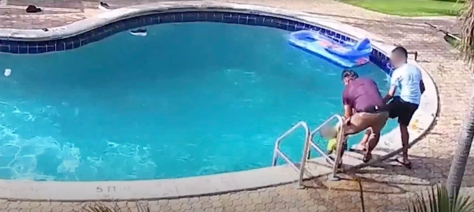 A man rescues a drowning boy from a swimming pool.