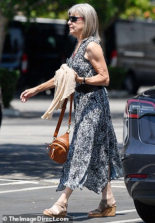 She additionally slipped into a pair of open-toed, wedge heels and carried a mini tan bag and cream-colored cardigan in her hand