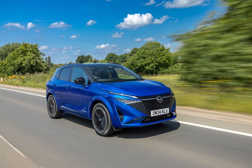 Blue Nissan Qashqai driving on a road.