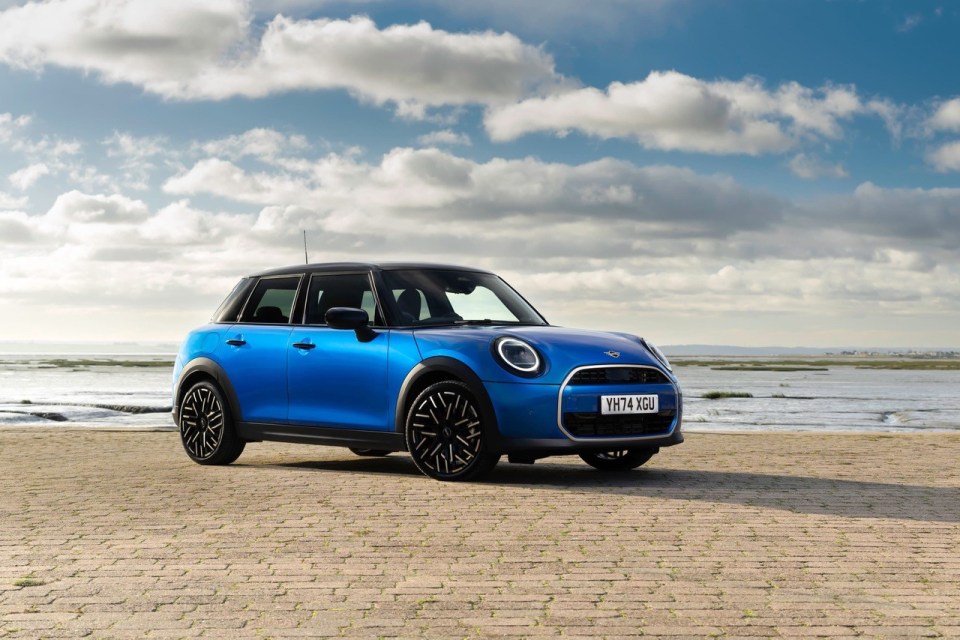 Blue Mini Cooper parked by the sea.