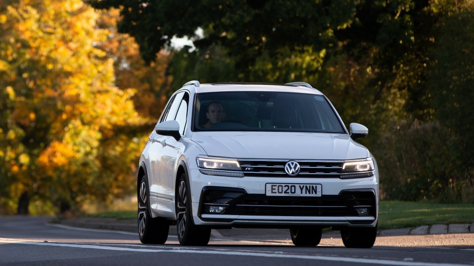White Volkswagen Tiguan driving on a road.