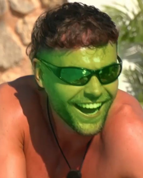 Man with green face filter smiling.