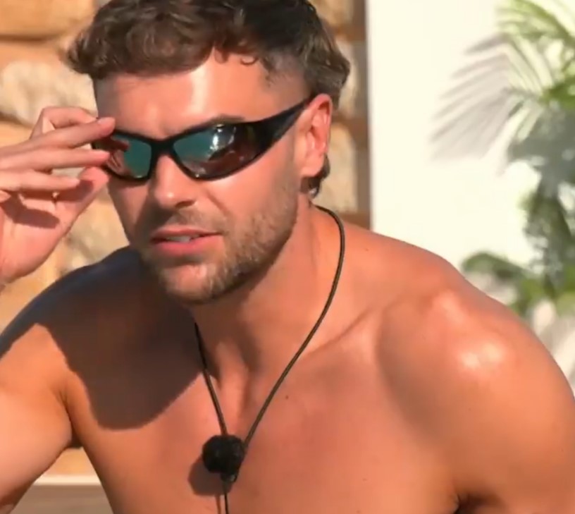 Man adjusting sunglasses on Love Island.