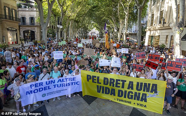 Demonstrators holds banners reading 'For another tourism model' and 'For the right to a decent life'